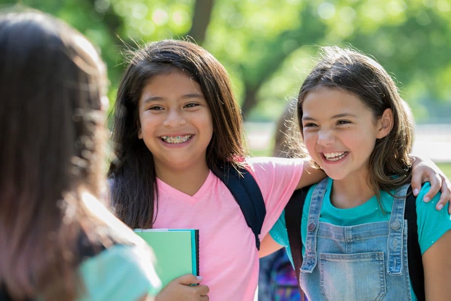 a girl with braces laughs with friends